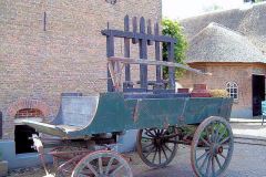 Oude-boerenkar-met-het-besloten-erf-en-de-karnmolen-op-de-achtergrond